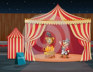 A lion circus with trainer performing on the circus tent