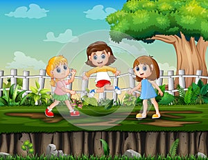 Three girls playing jump rope in the park