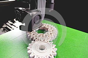 print head, bright green print bed and white helical gears with visible infill and layer. opblique view on process of 3D-printing