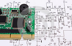 Printed circuit board lying on diagram of electronics, technology