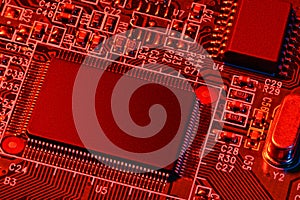 Printed circuit board and microchip, or cpu, in red light closeup - electronic component for digital equipment, concept for