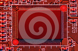 Printed circuit board and microchip, or cpu, in red light closeup - electronic component for digital equipment, concept for