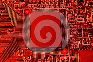 Printed circuit board and microchip, or cpu, in red light closeup - electronic component for digital equipment, concept for