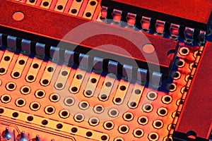 Printed circuit board and microchip in red light closeup - electronic component for digital equipment, concept for development of