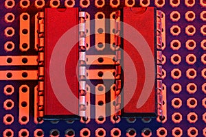 Printed circuit board and microchip in red light closeup - electronic component for digital equipment, concept for development of