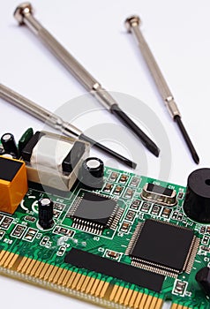 Printed circuit board and precision tools on white background, technology