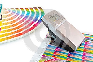 Printed color swatch, density meter and paint guide isolated on white background - clipping path. Measuring density of magenta