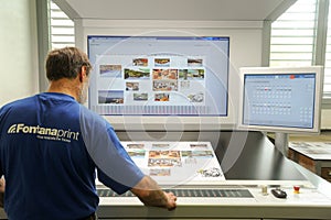 Printer checking a print run at table