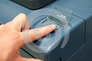 Printing machine control panel with start buttons. Worker`s hand, finger pushing the power button.