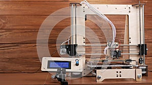 The printer prints the gear. The display shows information about nozzle movements and temperature.