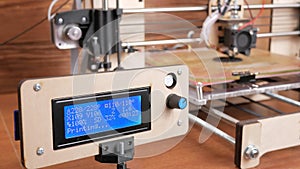 The printer prints the gear. The display shows information about nozzle movements and temperature. Moving camera