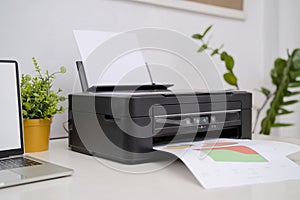 Printers and laptop computers are placed on the desk