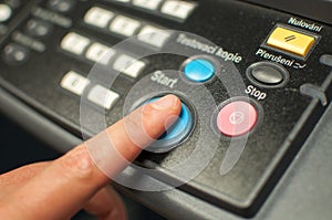 Printing machine control panel with start buttons. Worker`s hand, finger pushing the power button.