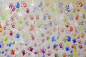 prints of children\'s hands in multi-colored paint on the wall