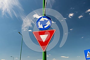 Priority street sign , roundabout against beautiful blue sky