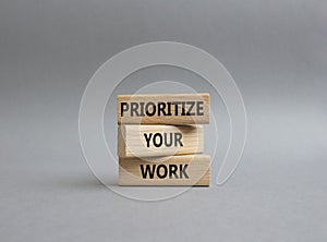 Priority symbol. Wooden blocks with words Prioritize your work. Beautiful grey background. Business and Prioritize your work