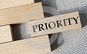 PRIORITY- word on a wooden bar on a gray background