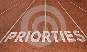 PRIORTIES written on running track, New Concept on running track text in white colour photo
