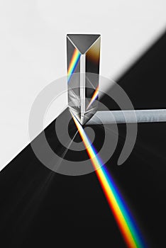 A prism dispersing sunlight splitting into a spectrum on a white background.