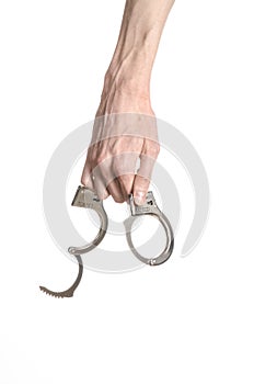 Prison and convicted topic: man hands with handcuffs isolated on white background in studio, put handcuffs on killer