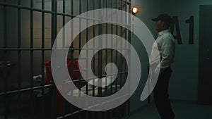 Prison employee with police baton talks to female prisoner