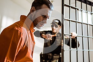 prison guard showing something to criminal