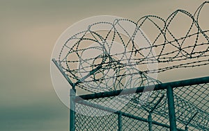 Prison security fence. Barbed wire security fence. Razor wire jail fence. Barrier border. Boundary security wall. Prison for