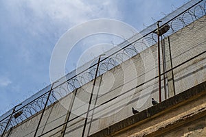 Prison wall against of blue sky with clouds photo