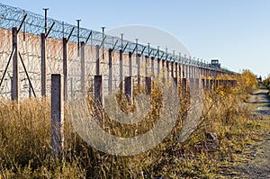 Prison wall and sharp wire barbs coiled