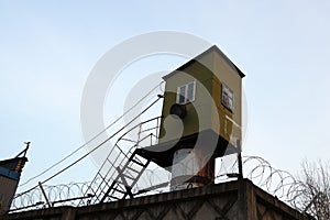 Prison watchtower behind barbed wire in the zone
