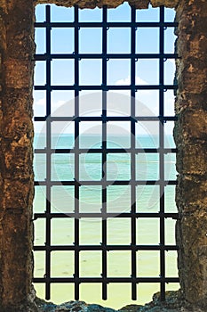 prison window bars in the castle overlooking the sea.