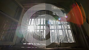 Prison window, sun shining through bars, handheld shot, slow motion