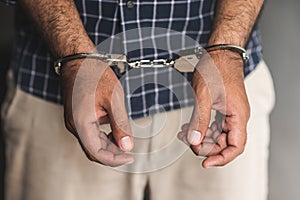 Prisoner man in jail with handcuffs. Close up Shackled in Hands