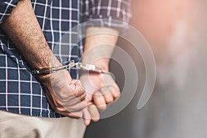 Prisoner man in jail with handcuffs. Close up Shackled in Hands