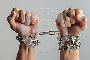 The prisoner`s hands are bound in metal chains photo