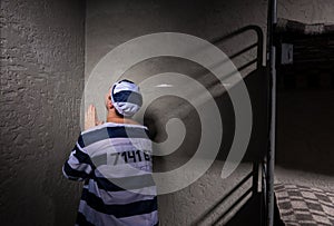 Prisoner is sitting in the corner and praying in a small prison