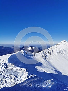 Pristine mountain snowscape under a clear blue sky.
