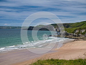 The pristine sand of Whiterocks Beach and coastal cliffs on the Antrim Causeway Coast in Northern Ireland, UK