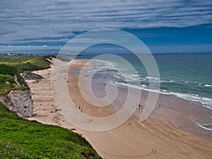 The pristine sand of Whiterocks Beach and coastal cliffs on the Antrim Causeway Coast in Northern Ireland, UK. Taken on a sunny