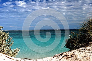 Pristine turquois waters through gap in the dunes at Ningaloo reef Western Australia