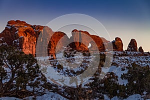 Pristine winter sunset view of Skyline Arch with snow in Arches National Park photo