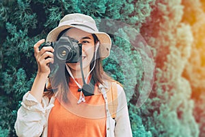 Pritty young Asian photographer girl teen travel with camera trip take a photo tourist lifestyle standing smile with hat