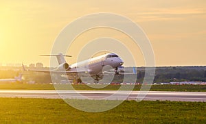 Private business jet plane takes off against the background of sunset clouds and Golden light from sun