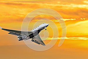 Private business plane flying under orange sky