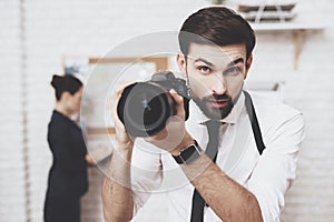 Private detective agency. Man is posing with camera, woman is looking at clues map.