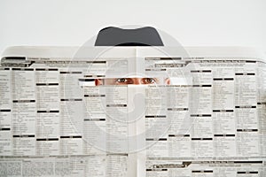 Private detective hiding watches through the newspaper over white background