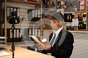 Private Detective or investigator working at desk in his office, drinking coffee and thinking of searching for solution