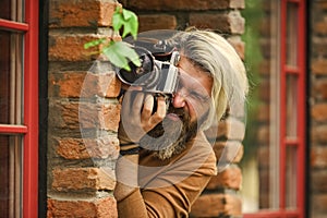 private detective. SLR camera. hipster man with beard use professional camera. photographer hold retro camera
