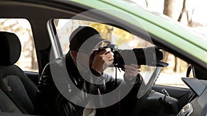 A private detective or a spy conducts surveillance of the object of surveillance. A man secretly taking pictures from