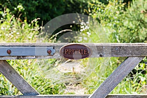 Private farm land fenced off by a large gate, close up of the private sign showing no access to the rural pathway